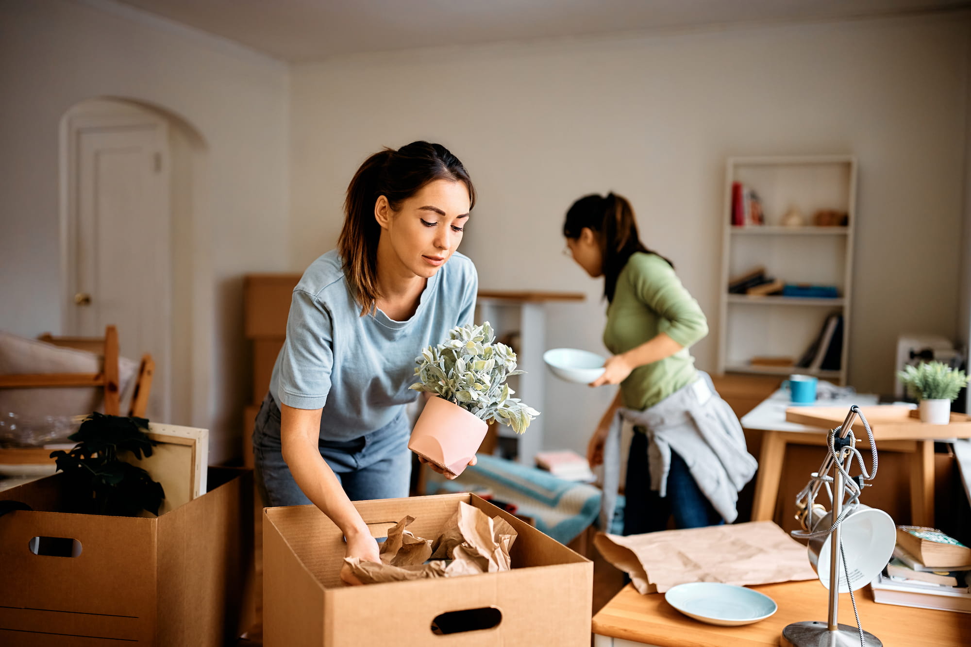 Frauen packen Deko-Artikel sorglos für den Umzug